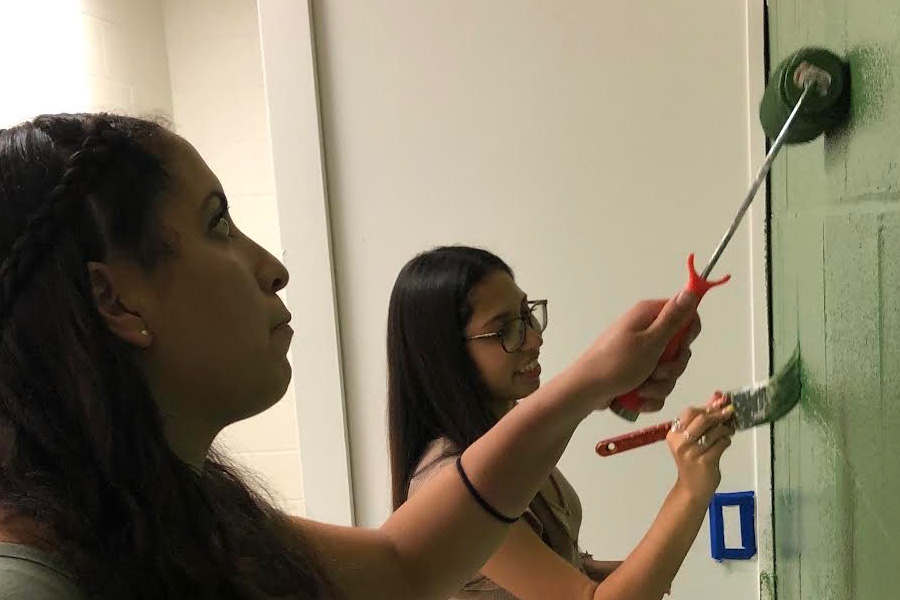 Jessica Adauto and Sylvana Gomez paint the teachers lounge's walls green for a farm-style look.