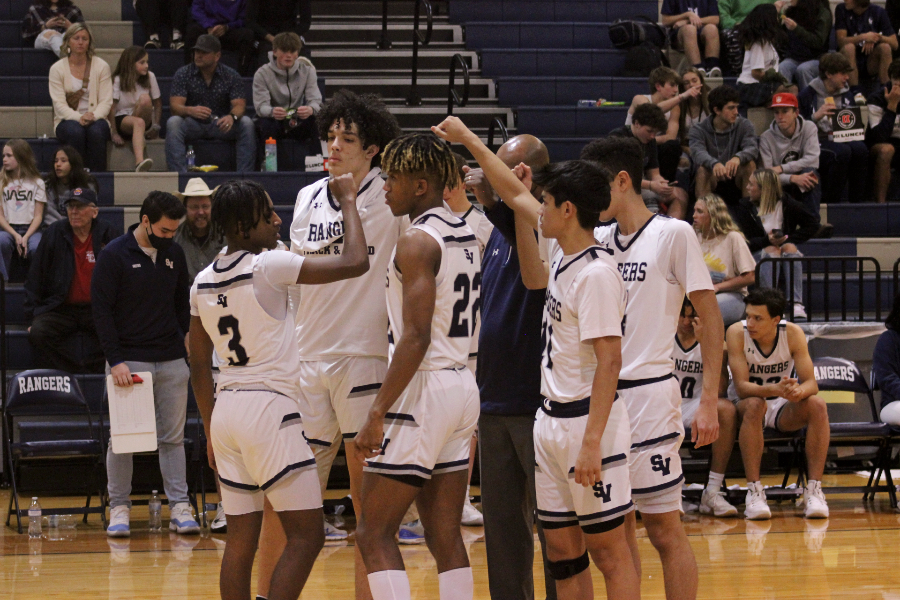 The boys basketball team  breaks after a huddle against Harlan. 