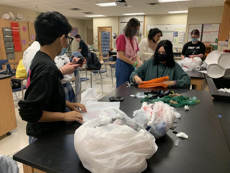 Craft club members cut plastic bags during their morning meeting. 