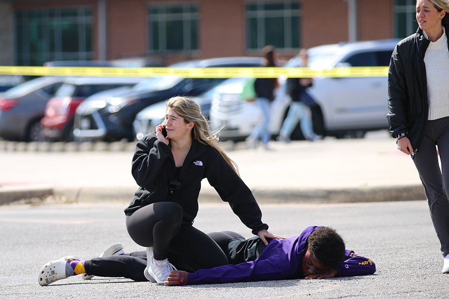 Senior Halie Fennen kneels over her friend Malachi Lane as she "calls" 911.