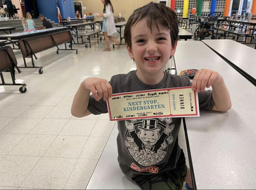 A preschool student holds up his "train" ticket  at Next Stop, Kindergarten.