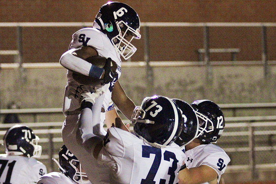 Freshman Quentin Sampson celebrates his 11-yard touchdown reception with senior center Ty Stone and senior quarterback Chase Senelick.