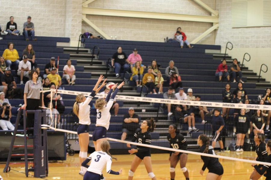 Teammates Lillie Johnson and Macie Mathis blocking a spike.