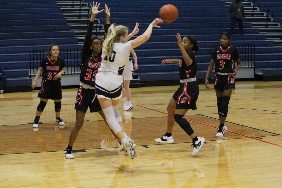 2021-22 senior Morgan Abbott lobs the ball over a Wagner opponent.