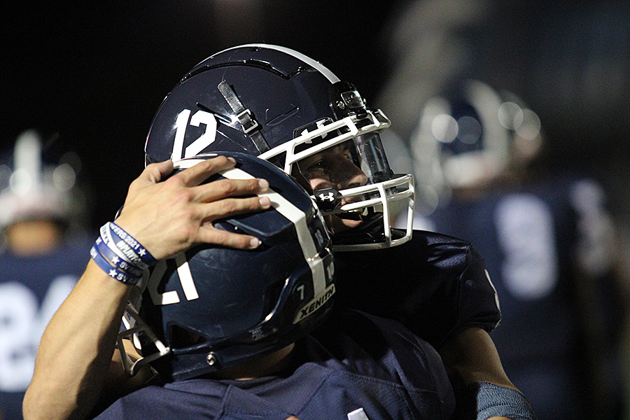 Senior quarterback Chase Senelick embraces a teammate in celebration at the Boerne Champion.