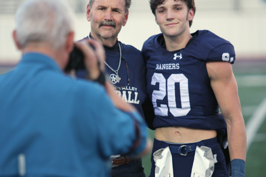 Thomas Elliott and his father smile for photographer Sam Roberts during senior night Nov 4.