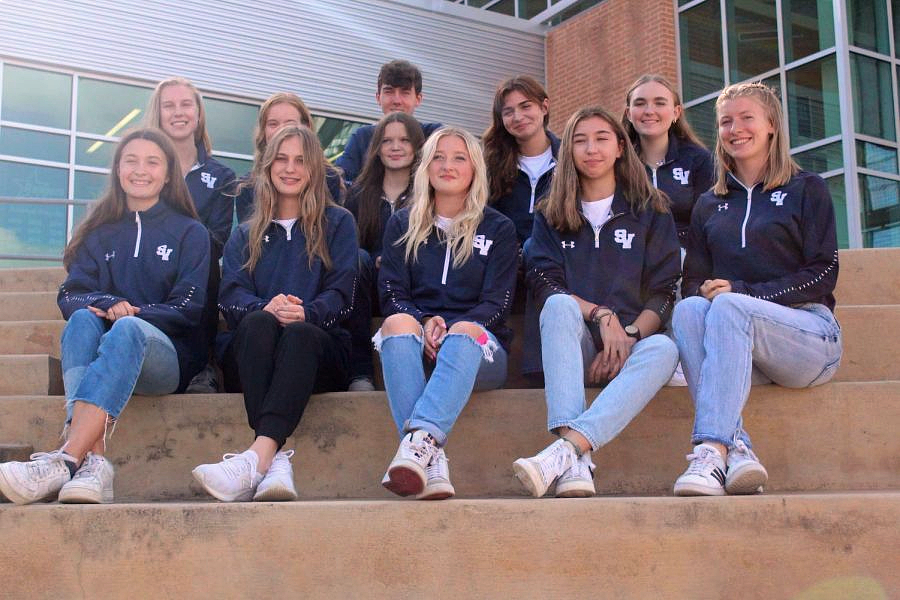 The girls cross country team and Bradyn Youngdahl gather after the state sendoff on Nov. 4 in the main hallway.