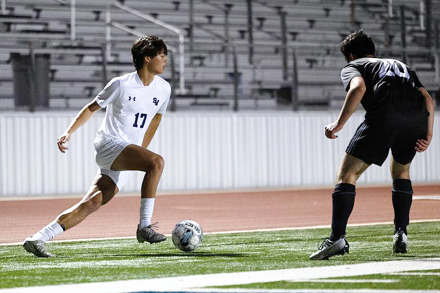 Sophmore Keller Chourb looks for an open teammate, while being watched carefully by his opponent. 