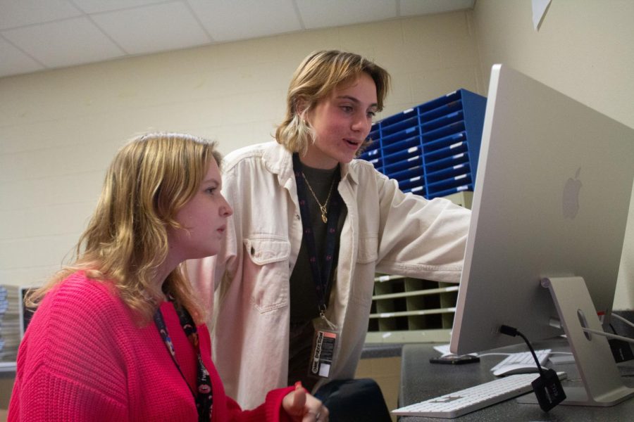 Editor-in-Chief Emma Siebold helps yearbook editor Annie Osborne with building a portfolio. 