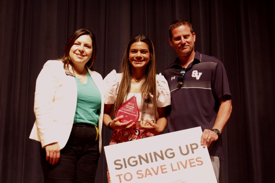 Junior Alex Smithwick stands with LLS Regional Director Clarissa Flores (left) and varsity soccer coach Jason Adkins (right). Smithwick,a  forward on the girls soccer team, won Student Visionary of the Year for her efforts in raising money for blood cancer.