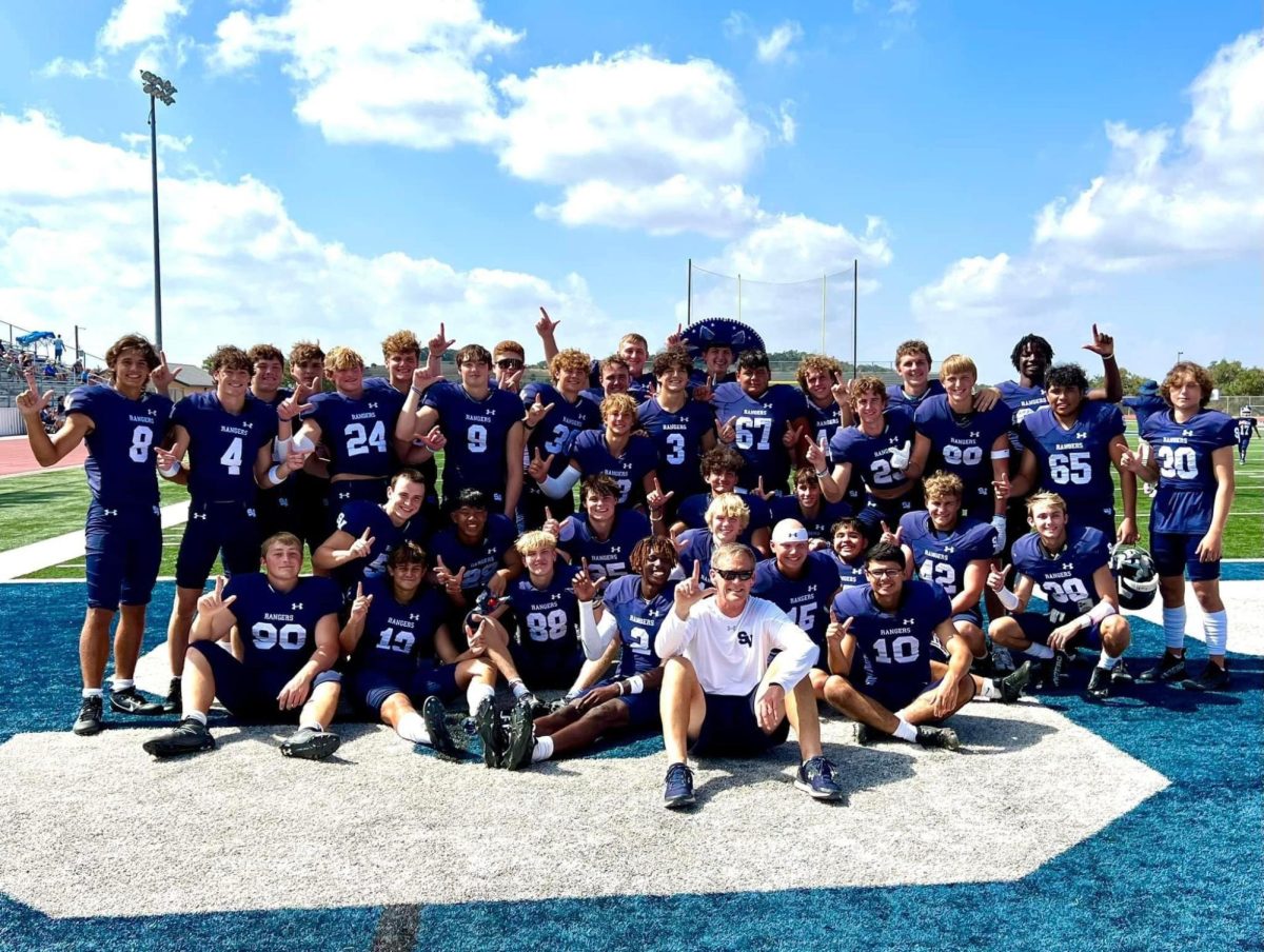 Varsity football along side with head coach Larry Hill pose for a picture on their booster club media day. 