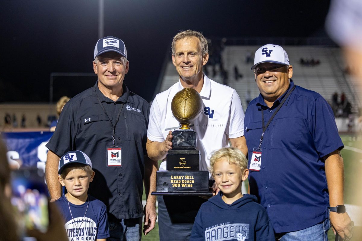 Flanked by superintendent Dr. John Chapman III and Director of Athletics Brian Martinez, head football coach Larry Hill receives a trophy celebrating his 300th career win Friday night. The Rangers defeated Wagner 24-7 at home.