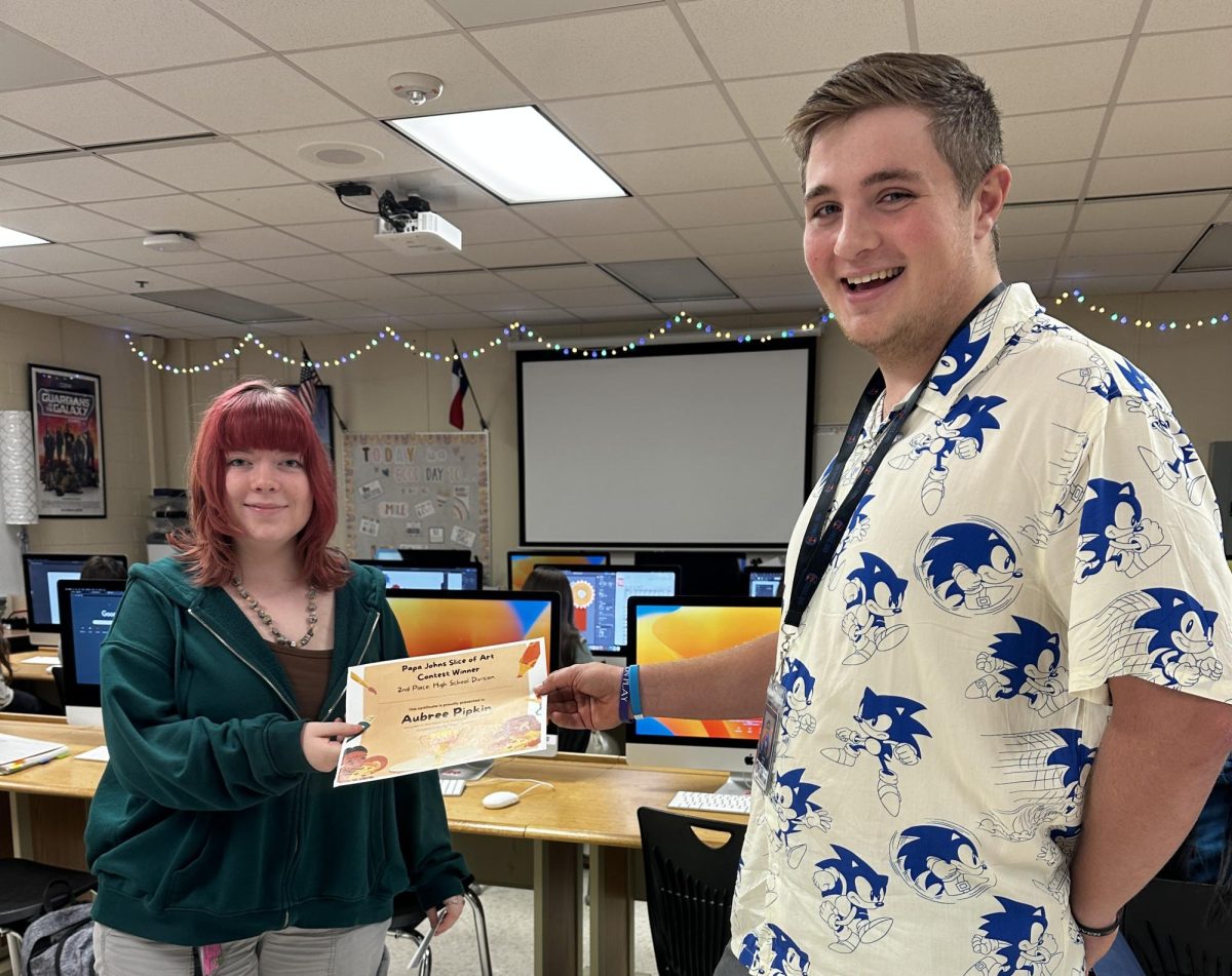 Senior Austin Ison hands junior Aubree Pipkin her certificate for placing second in the Papa John's Slice of Art contest.