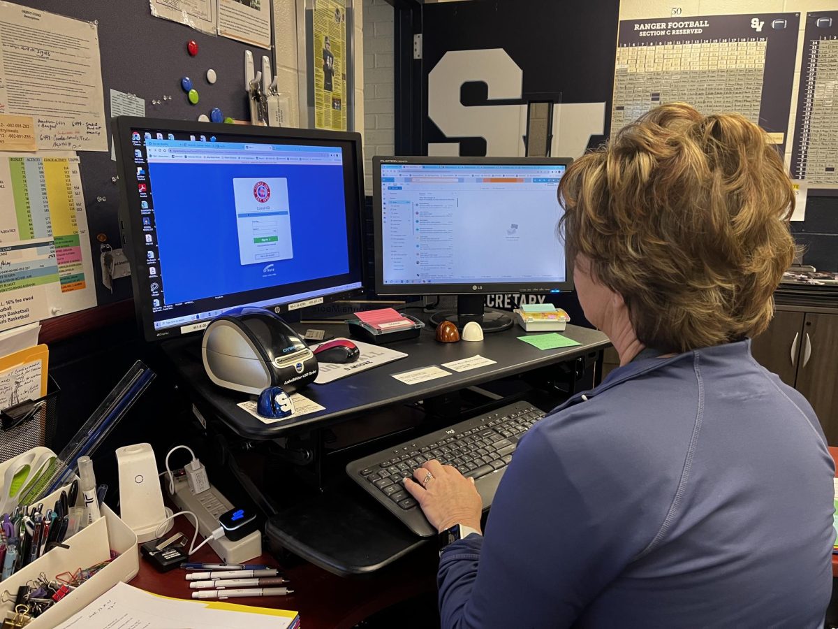 Athletic Secretary Donna Moore answers emails at her desk in preparation for Friday's state final football game against the Aledo Bearcats. 