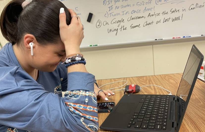 During first period english IV Katie Farmer plugs her airpods in her ears and watches videos on her phone while her chromebook assignment is incomplete 