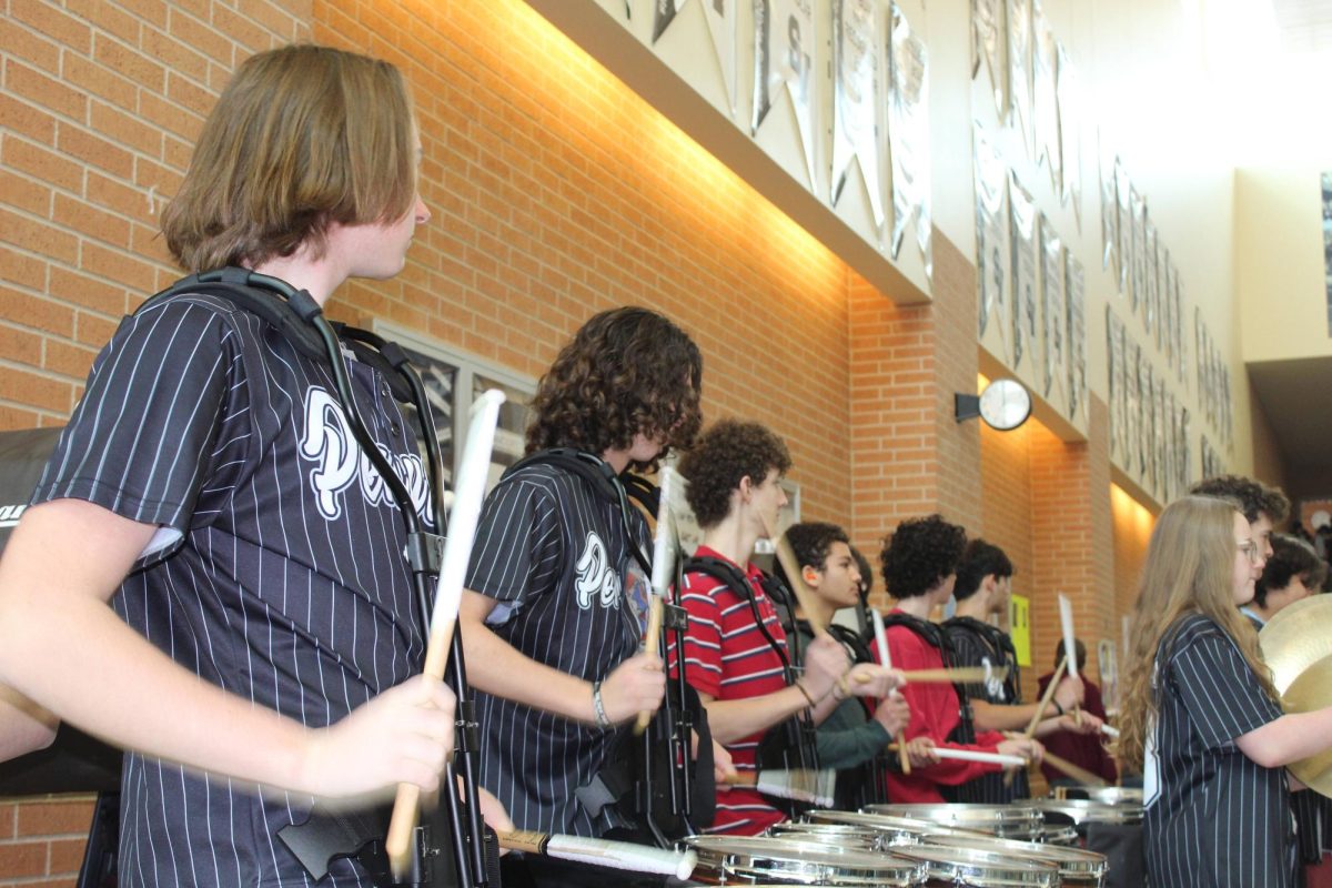 Senior Frankie Omelanchuk and junior Jameson Maldonado play with the drumline at the wrestling send off.