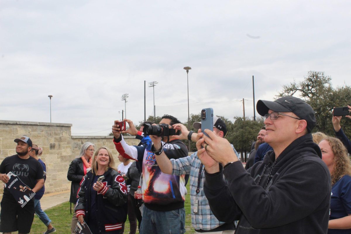 Wrestling parents take photos of their kids who will compete at the state competition this weekend.