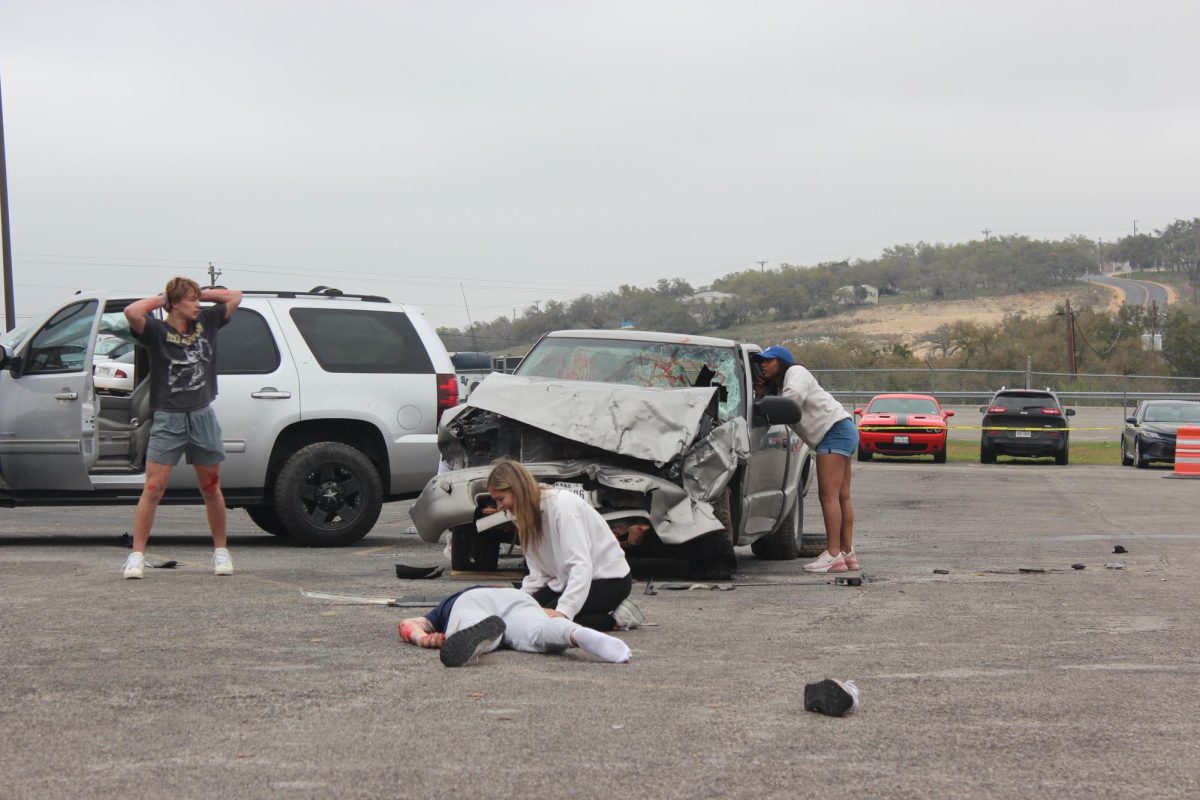 Seniors Kannon Day, Karlie Jackson and Victoria Williams wait for first responders to arrive during the Shattered Dreams presentation March 7.