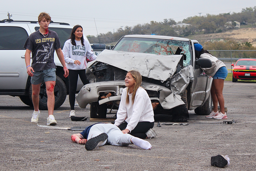 Senior Karlie Jackson cries over senior Maverick Minister's body during the Shattered Dreams presentation March 7. Students watched a video in their second period before heading to the rotunda parking lot.