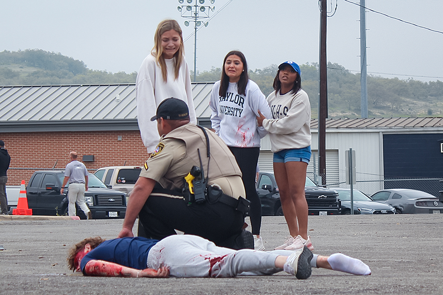 Local deputy checks senior Maverick Minister's pulse during the Shattered Dreams presentation March 7.