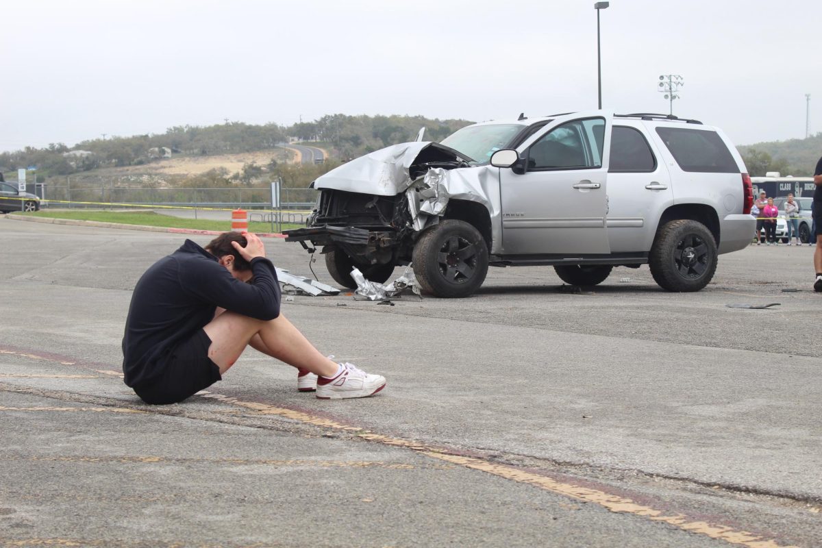 Senior Ryder Bonser sits distraught after his friend is pronounced dead during the Shattered Dreams demonstration March 7. He was later arrested for driving while intoxicated.