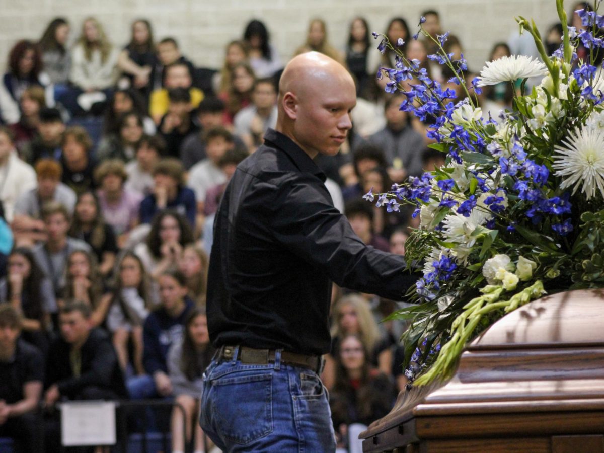Senior Ryland Walker places a flower on Senior Maverick Minister's casket at the Shattered Dreams March 8. All the broken hearted placed a flower to honor the departed.