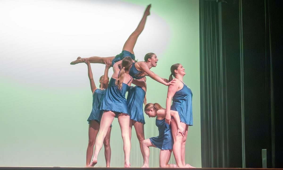 Junior Kylah Moller is lifted up by her teammates during the varsity dance team's performance at Founder's Day.