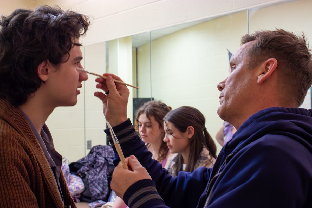 James Berry gets some help with his makeup from technical theater director James Black before a rehearsal for the one-act play "Iphigenia." The cast and crew are headed to area after winning district and bidistrict.