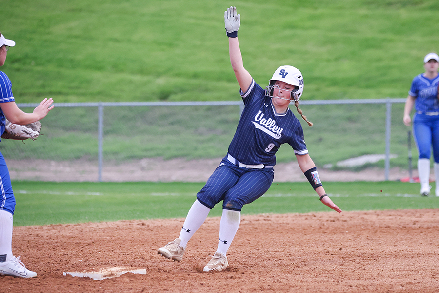 In her approach to third base, sophomore Kamryn Prater prepares to slide to beat the throw out.