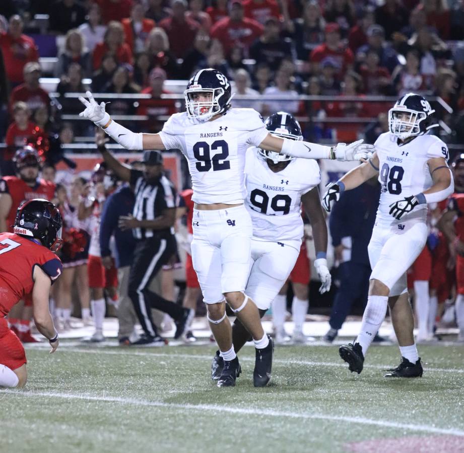 Hudson Woods throws his arms out after a play before getting into position