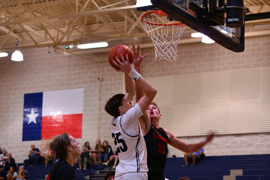 Junior Carter Majors drives the ball to the hoop and takes a contested layup against his Canyon opponent.