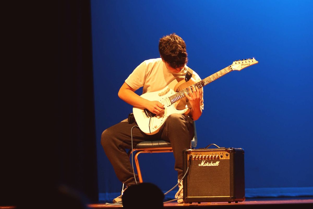 Freshman Max Chacon plays an electric guitar at the talent show Feb. 27. Chacon was the first to perform.