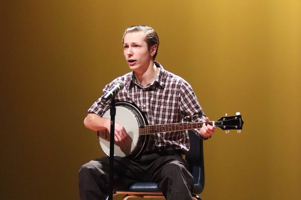 Senior Jack Ruston plays the banjo while singing for his talent show performance.