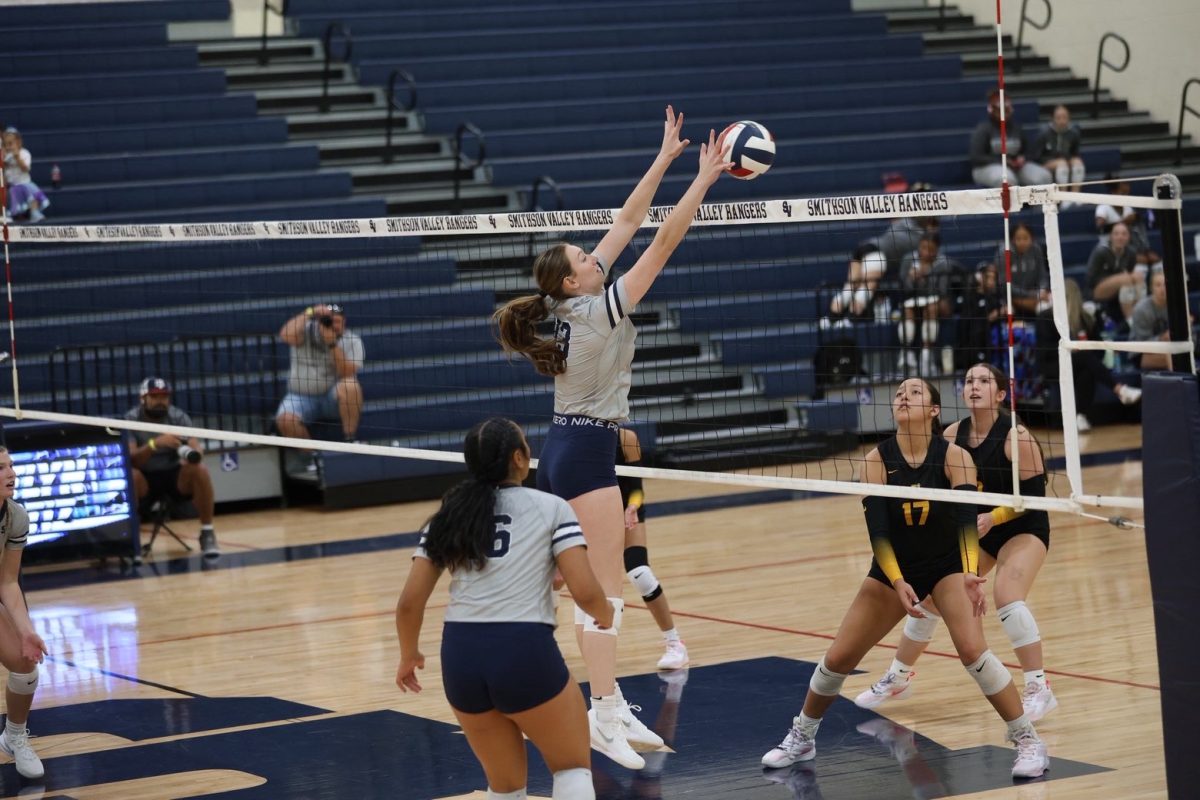 Senior Jacey Owens blocks the ball from Brennans' attempt to score a point. The team looks to enter its second round of distirct this Friday.